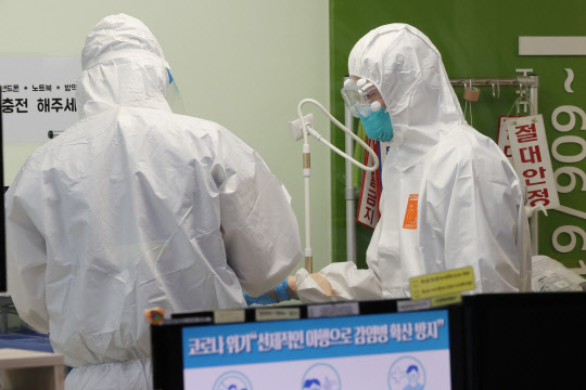 이달 9일 오후 서울 광진구 혜민병원의 음압병동에서 의료진이 분주한 모습으로 환자를 돌보고 있다. <연합뉴스>